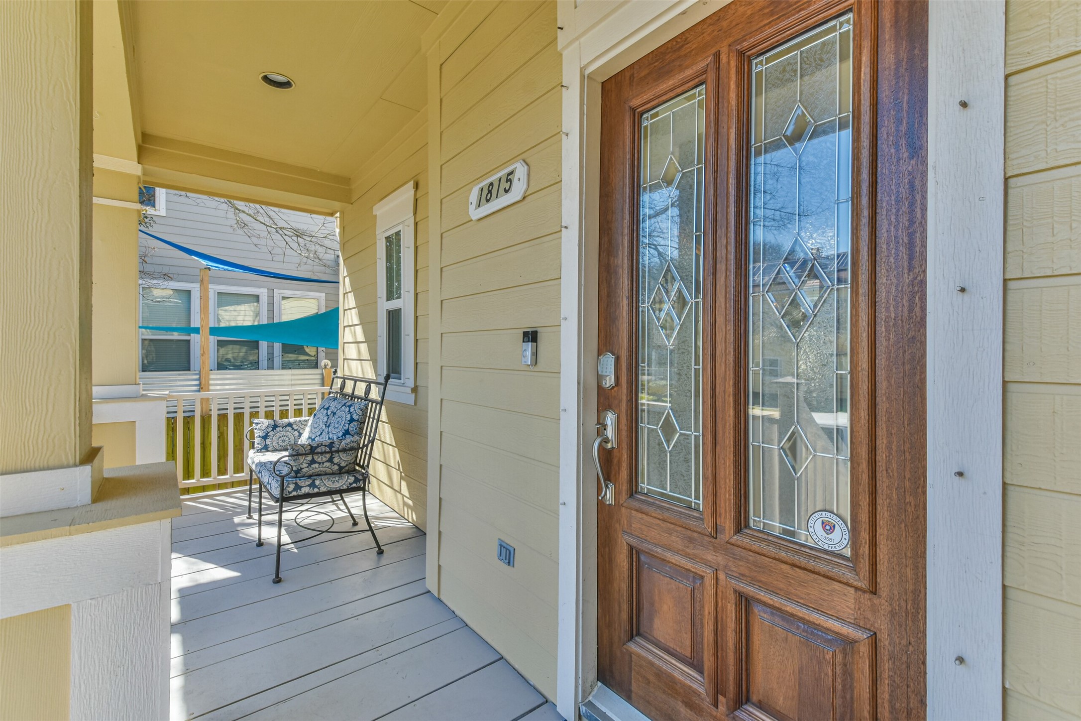 1815 28th Street Galveston, TX 77550 - Photo 2 of 42 Charming front porch with a decorative glass-paneled wooden door and cozy seating area. Perfect for relaxation and welcoming guests.