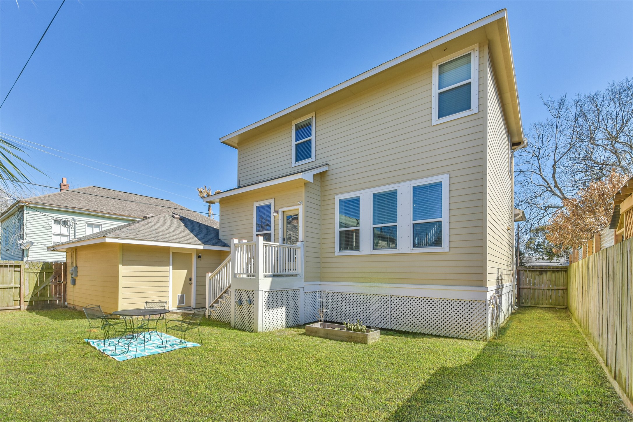 1815 28th Street Galveston, TX 77550 - Photo 22 of 42 Charming two-story home with a spacious fenced backyard, featuring a small patio area perfect for outdoor dining. Ideal for buyers seeking a private outdoor space.