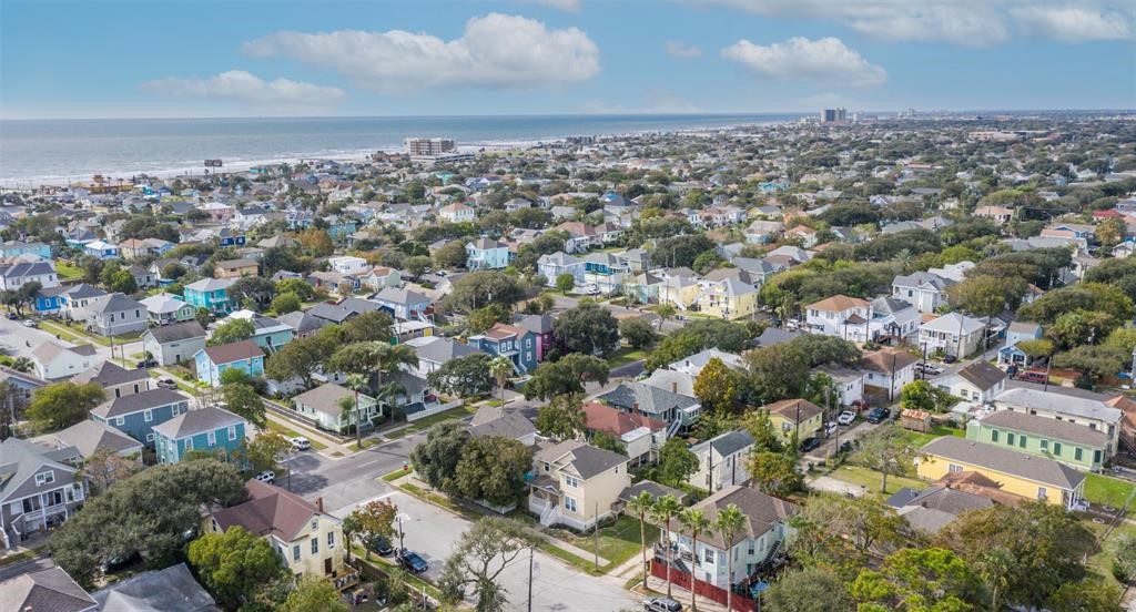 1815 28th Street Galveston, TX 77550 - Photo 23 of 42 This aerial photo showcases a charming coastal neighborhood with colorful homes, tree-lined streets, and proximity to the ocean, offering a scenic and inviting community atmosphere.