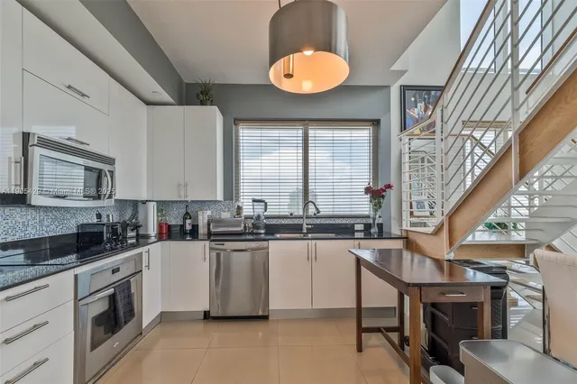 a kitchen with a sink appliances cabinets and furniture