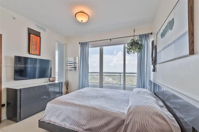 a bedroom with a bed and a flat screen tv