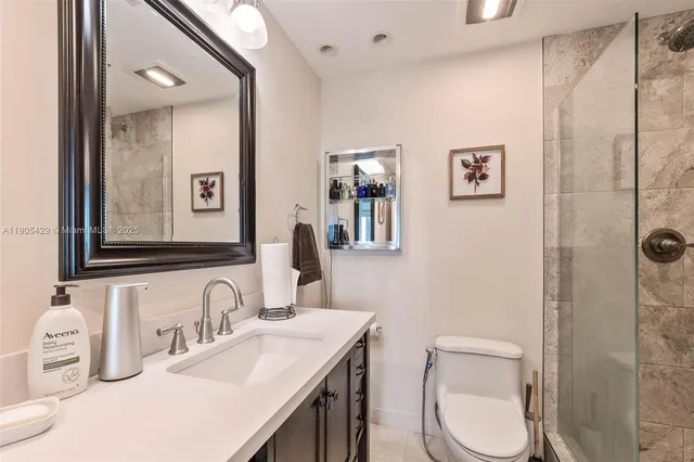 a bathroom with a granite countertop toilet sink and mirror