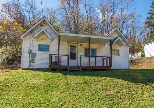 a view of a house with a yard and porch