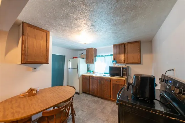 a kitchen with stainless steel appliances a stove refrigerator sink and microwave