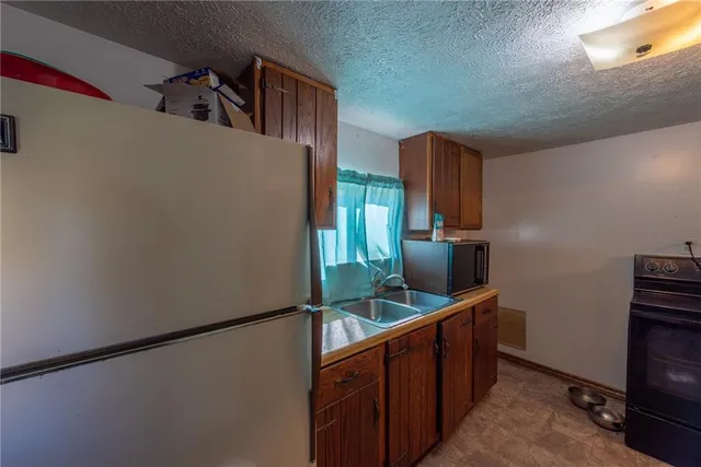 a kitchen with stainless steel appliances granite countertop a refrigerator and a sink