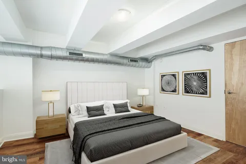 a bedroom with bed and painting on the wall