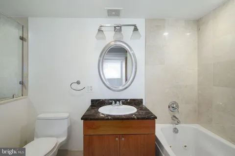 a bathroom with a sink a toilet and a mirror