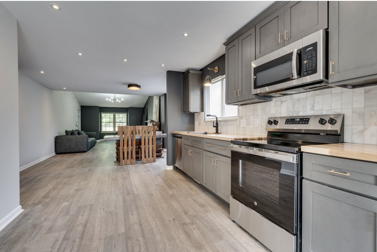 515 Upsall Drive Antioch, TN 37013 - Photo 12 of 31 a kitchen with stainless steel appliances granite countertop wooden cabinets a sink dishwasher a stove and a microwave oven with wooden floor