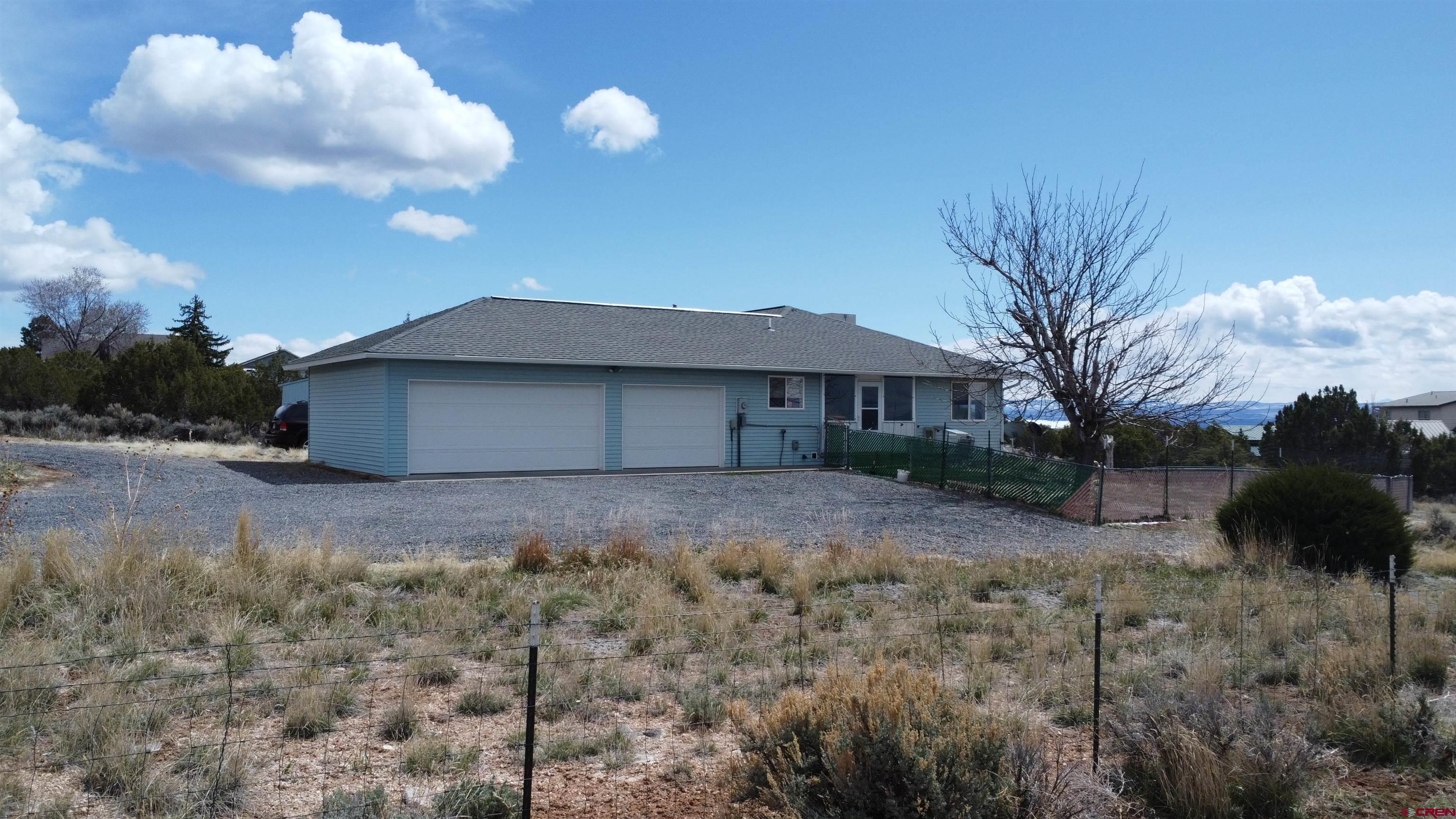16709 Cedar Lane Cedaredge, CO 81413 - Photo 13 of 35 a view of a house with a yard and a large tree