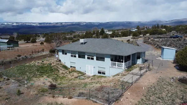 an aerial view of a house with a garden and lake view