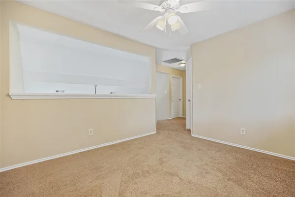 an empty room with a view of a kitchen