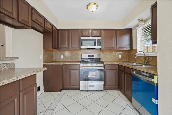 a kitchen with a sink stove and microwave