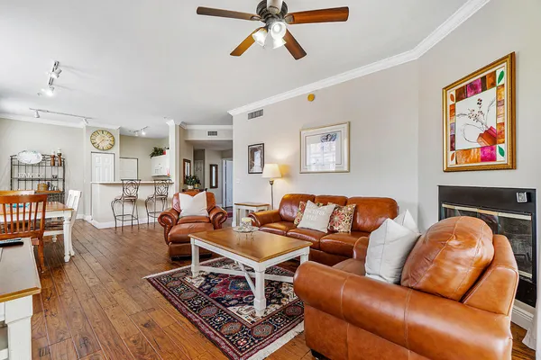 a living room with furniture a wooden floor and a chandelier