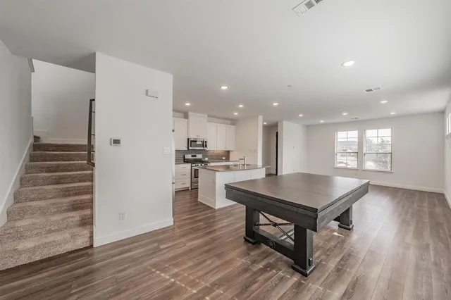 a kitchen with kitchen island a stove and a wooden floors