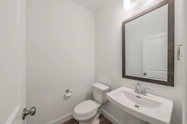 a bathroom with a toilet a sink and mirror