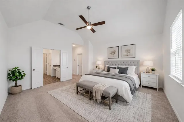a spacious bedroom with a bed and a chandelier