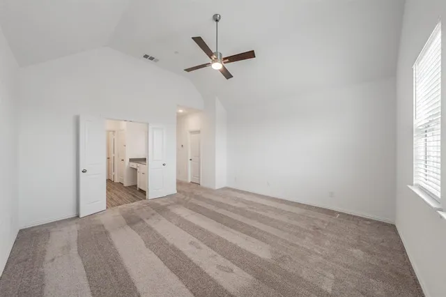 a view of a bedroom with a bed and a window