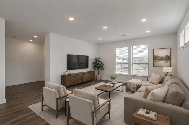 a living room with furniture a flat screen tv and a large window