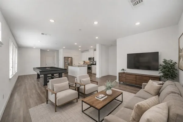 a living room with furniture wooden floor and a flat screen tv