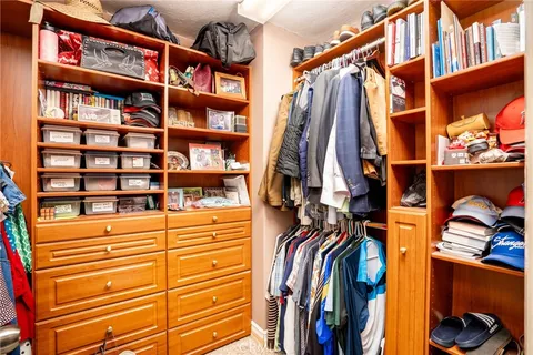 a view of walk in closet with clothes and shoes