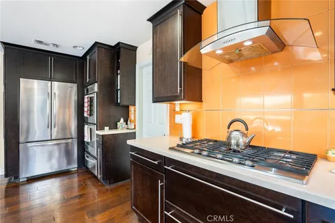a kitchen with a refrigerator and a stove top oven