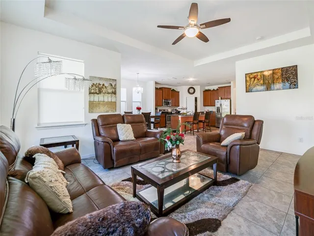 a living room with furniture a ceiling fan and a rug