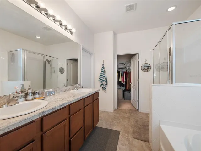 a spacious bathroom with a double vanity sink and a mirror