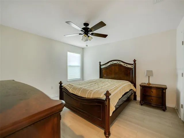 a bedroom with a bed and a ceiling fan