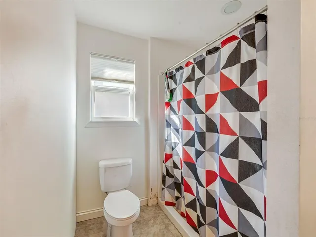 a bathroom with a toilet and shower curtain