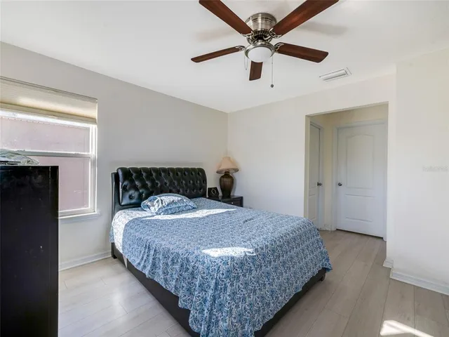 a bedroom with a large bed and a ceiling fan
