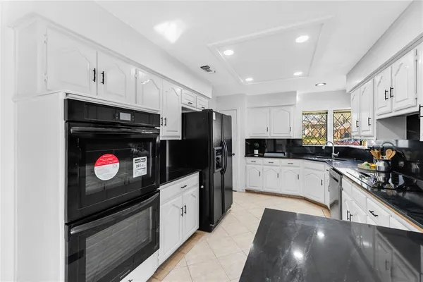 a kitchen with stainless steel appliances kitchen island granite countertop a stove a sink and a microwave