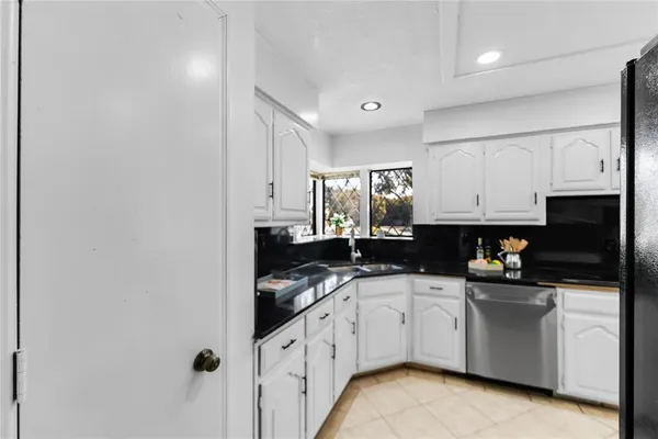 a kitchen with white cabinets and appliances