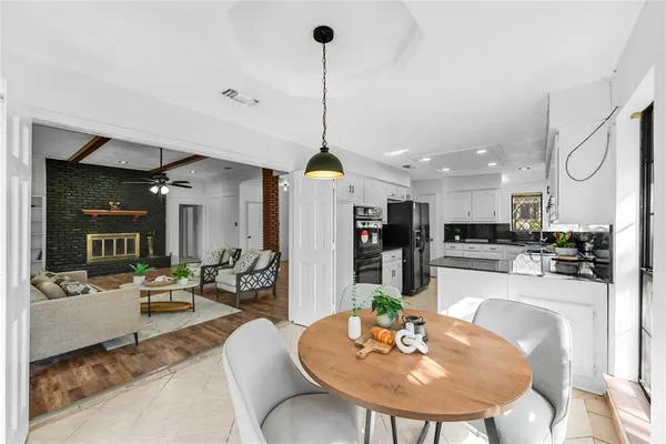 a dining room with furniture a kitchen and chandelier