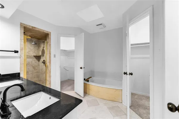 a bathroom with a tub shower and sink
