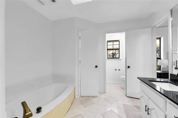 a spacious bathroom with a tub shower and mirror