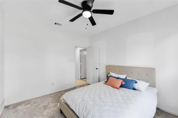 a bedroom with a bed and a ceiling fan