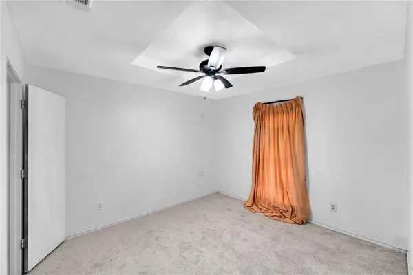 an empty room with closet and a chandelier fan