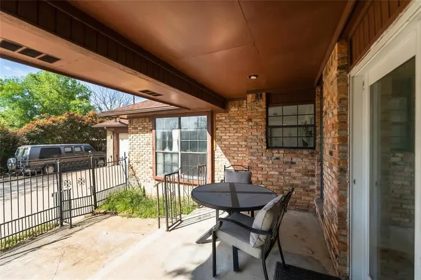 a view of a patio with table and chairs next to a yard