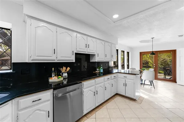 a kitchen with white cabinets and sink