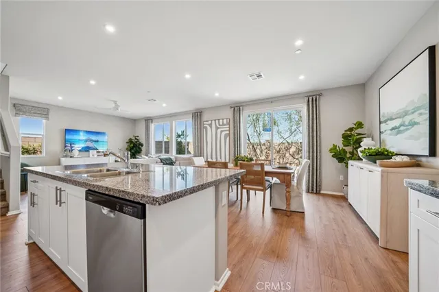 a kitchen with granite countertop a sink and white cabinets