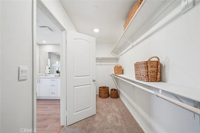 a view of a hallway with wooden floor and a bathroom