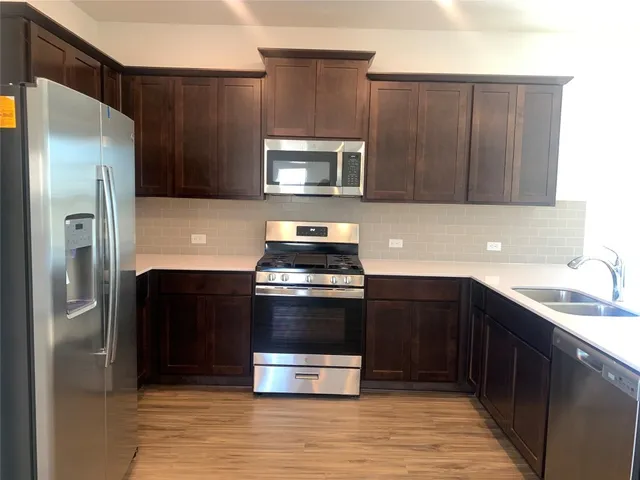 a kitchen with stainless steel appliances granite countertop a sink and a stove