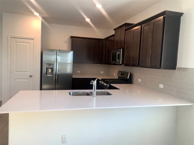 a kitchen with granite countertop stainless steel appliances and wooden cabinets