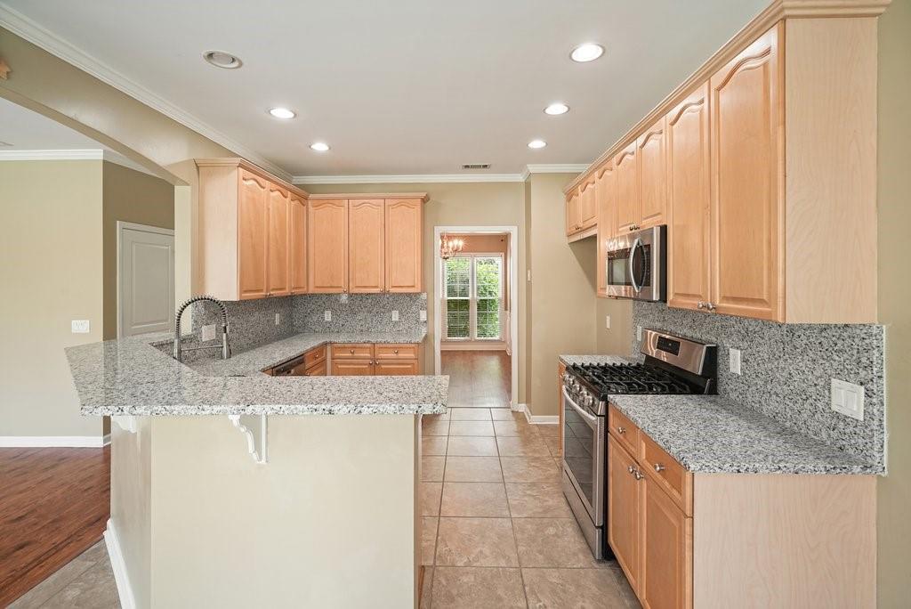 412 Middlebrooke Street Canton, GA 30115 - Photo 13 of 32 a kitchen with stainless steel appliances granite countertop a sink a stove and a refrigerator