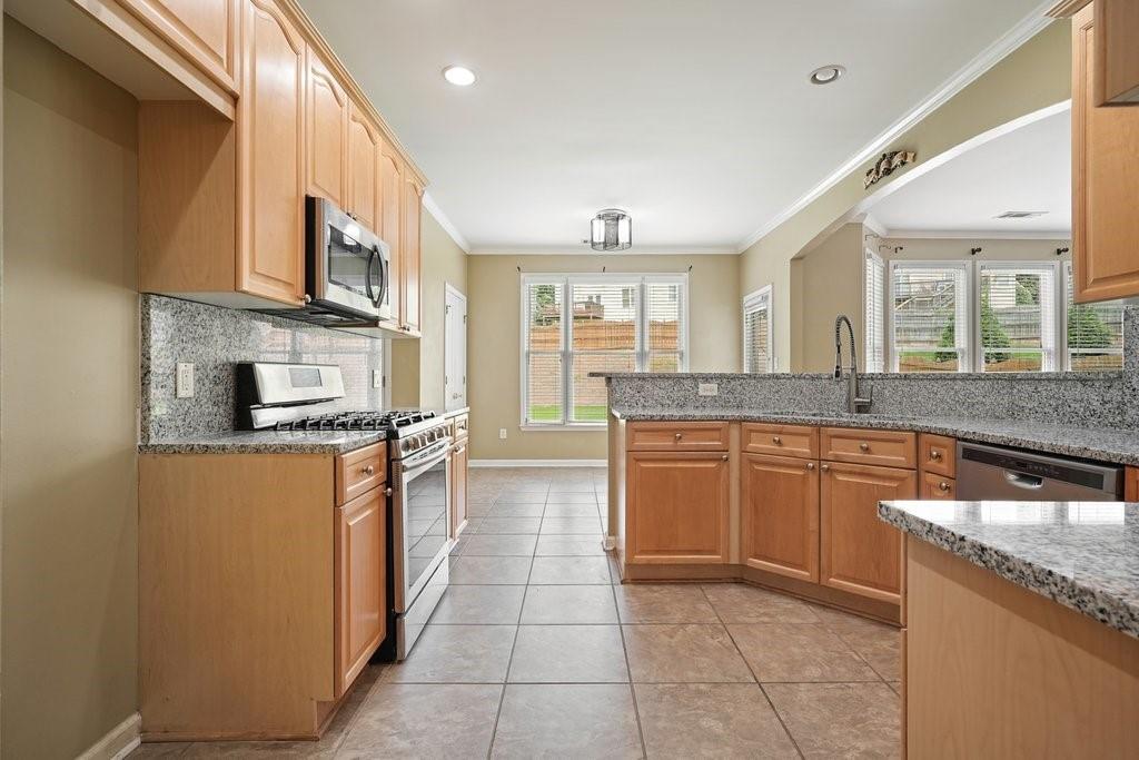 412 Middlebrooke Street Canton, GA 30115 - Photo 14 of 32 a large kitchen with stainless steel appliances granite countertop a large stove top oven a sink and dishwasher