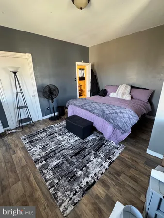 a view of an empty room with wooden floor and stairs