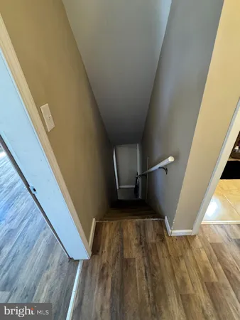 a view of a hallway with wooden floor and furniture