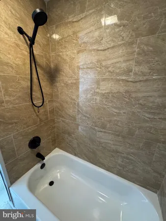 a view of a hallway with wooden floor and a living room