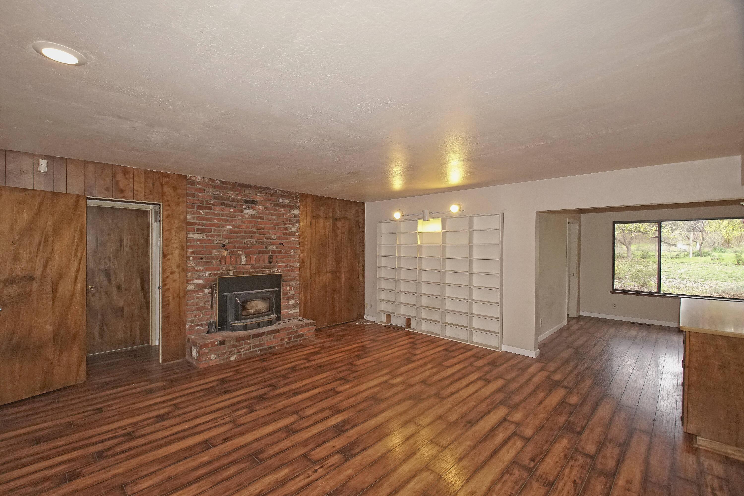 8440 Redbank Road Redding, CA 96001 - Photo 21 of 49 wooden floor fireplace and windows in an empty room