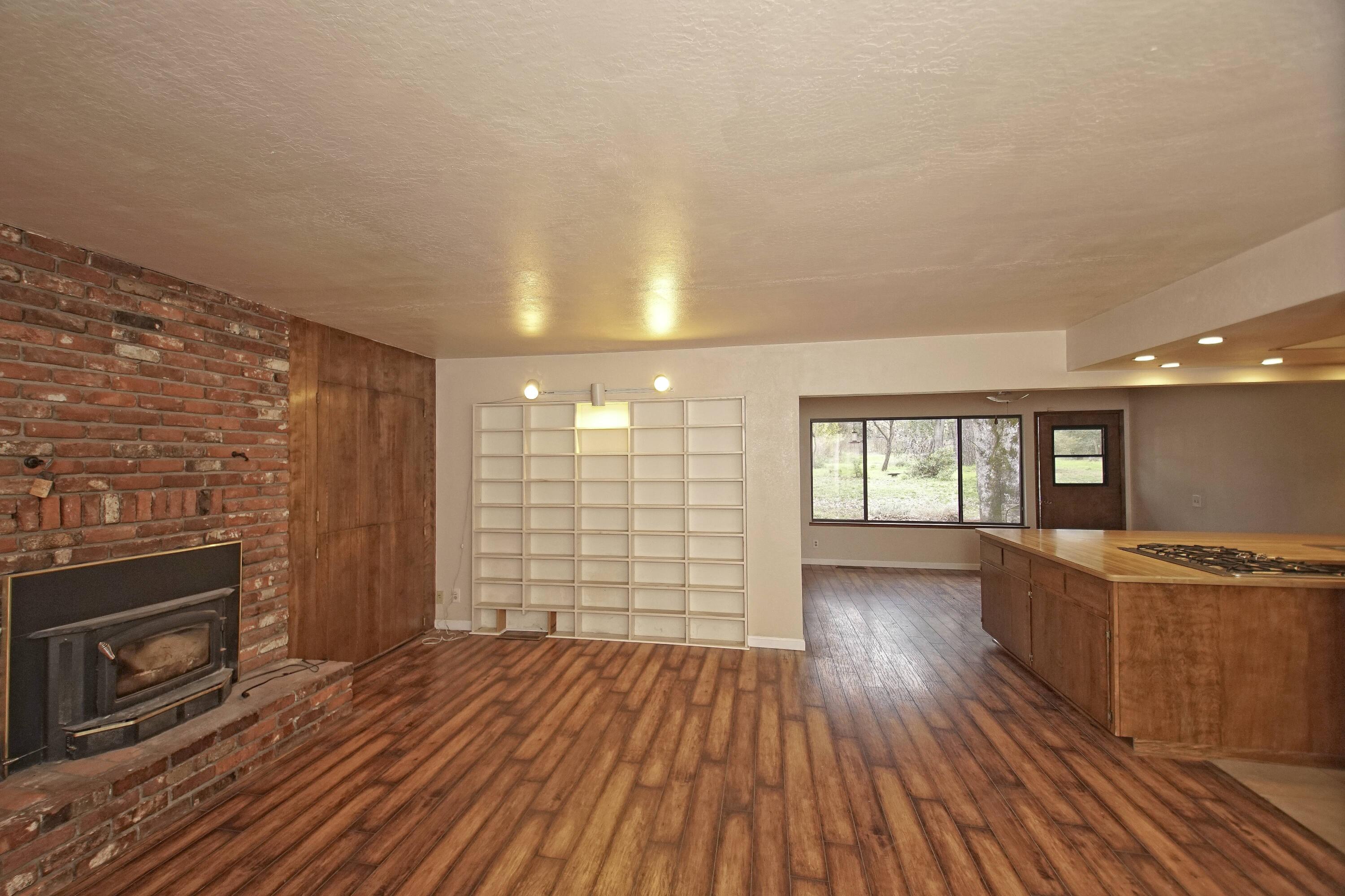 8440 Redbank Road Redding, CA 96001 - Photo 23 of 49 wooden floor in an empty room with a fireplace